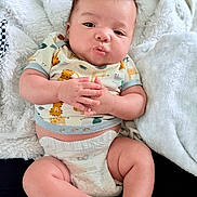 Kyle joined the competition — help win amazing prizes! baby, infant, diaper, clothing, cute, pout, hands, fluffy_blanket, animal_print, skin, legs, sitting, portrait, indoors, soft_texture, adorable, child, young, expression, comfortable