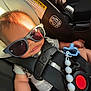 Kyle joined the competition — help win amazing prizes! baby, sunglasses, car_seat, child, seatbelt, pacifier, infant, safety, restraint, cute, accessory, black_strap, red_button, blue_pacifier, head_support, warning_label, car_interior, small_person, casual_clothing, sunlight