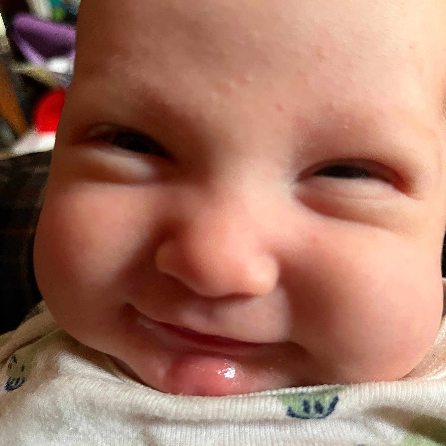 Isaiah is registered to the contest to win money with this photo: baby, infant, child, face, smiling, grinning, eyes, nose, mouth, tongue, portrait, close_up, indoors, clothing, onesie, patterned_fabric, cheeks, happy, head, photography