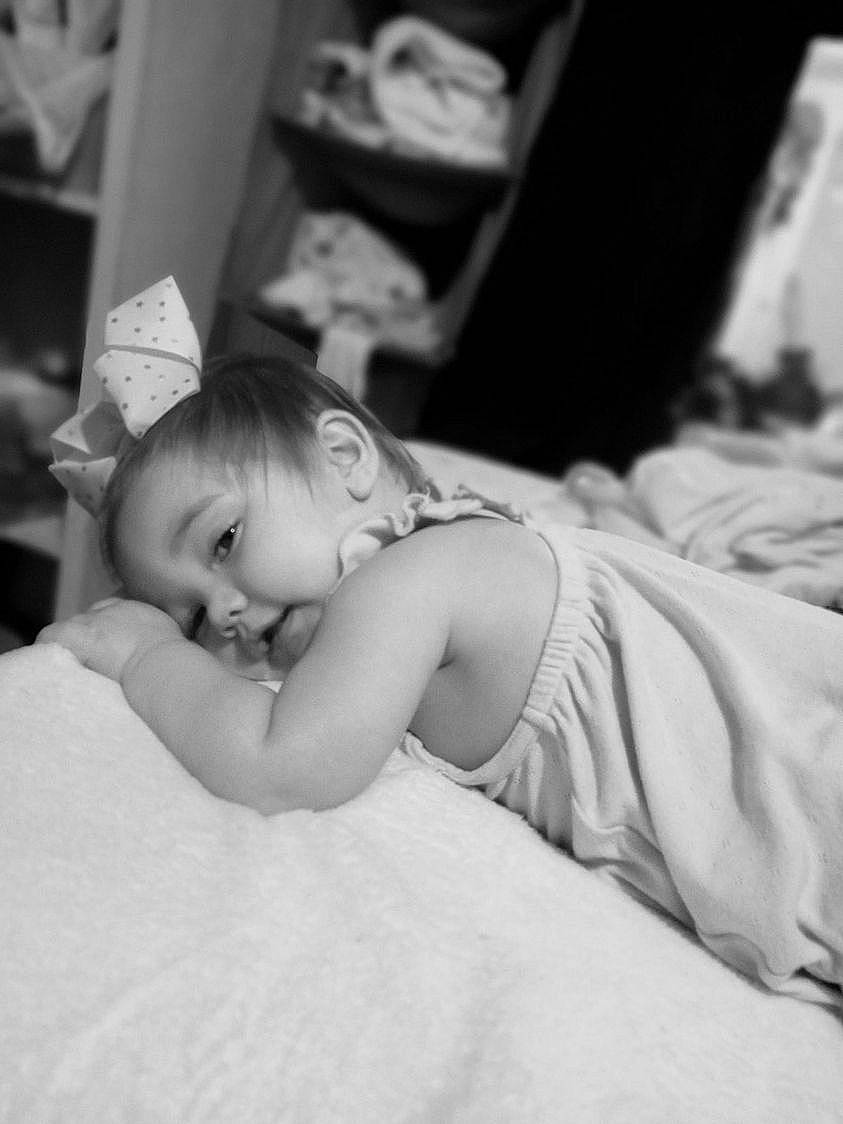 Serenity is registered to the contest to win money with this photo: baby, bed, bedding, bedroom, black_and_white, child, comfort, dress, event, flash_photography, fun, gesture, happy, human_body, linens, monochrome, monochrome_photography, person, sitting, smile