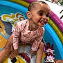 toddler, child, smiling, splashing, inflatable_pool, water, swimsuit, toy, elf_doll, outdoor, play, happy, cute, summer, fun, colorful, sitting, baby, joyful, skin