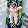Eve is registered to the contest to win money with this photo: baby, snowsuit, sled, snow, winter, child, outdoor, pink, cold, smile, cozy, toy, play, recreation, fun, winter_clothing, infant, happy, person, cold_weather