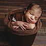 Xavier joined the competition — help win amazing prizes! baby, newborn, sleeping, bucket, brown, wooden_floor, cozy, infant, portrait, peaceful, soft_texture, cute, hands, face, closed_eyes, resting, warm_tones, wrapped, child, indoors