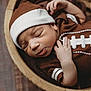 Xavier is registered to the contest to win money with this photo: newborn, baby, sleeping, infant, brown_outfit, hat, wooden_bowl, blanket, closeup, cute, peaceful, portrait, indoors, soft_lighting, child, resting, tiny_hand, cozy, sleep, adorable