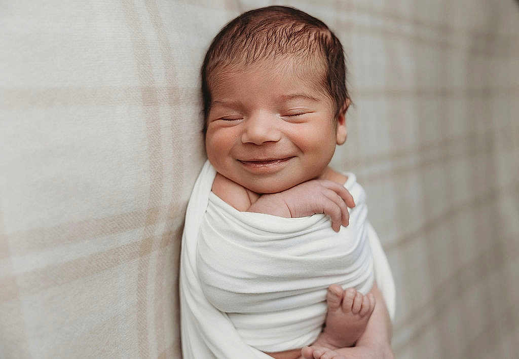 Xavier joined the competition — help win amazing prizes! newborn, baby, smiling, wrapped, blanket, infant, sleepy, portrait, closeup, soft, peaceful, cute, child, face, skin, hand, foot, indoors, plaid, resting