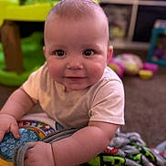Zayden is registered to the contest to win money with this photo: baby, child, toy, blanket, indoor, playtime, smiling, face, person, infant, cute, colorful, carpet, soft, young, happy, hand, clothing, background, focus