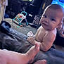 Zayden is registered to the contest to win money with this photo: baby, infant, child, barefoot, living_room, carpet, toy, walker, fish_tank, furniture, couch, smiling, face, person, home_interior, carpeted_floor, relaxed, indoor, playtime, cute