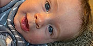 Bentley is registered to the contest to win money with this photo: baby, infant, face, eyes, carpet, blanket, blue_eyes, close_up, skin, expression, lying_down, indoors, soft_light, curious, cute, child, person, head, mouth, smile