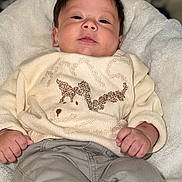 Ethan joined the competition — help win amazing prizes! baby, infant, child, sweater, dog_design, pants, white_shoes, blanket, holiday_decorations, christmas, face, hands, cute, smiling, indoors, portrait, soft_lighting, cozy, seated, young