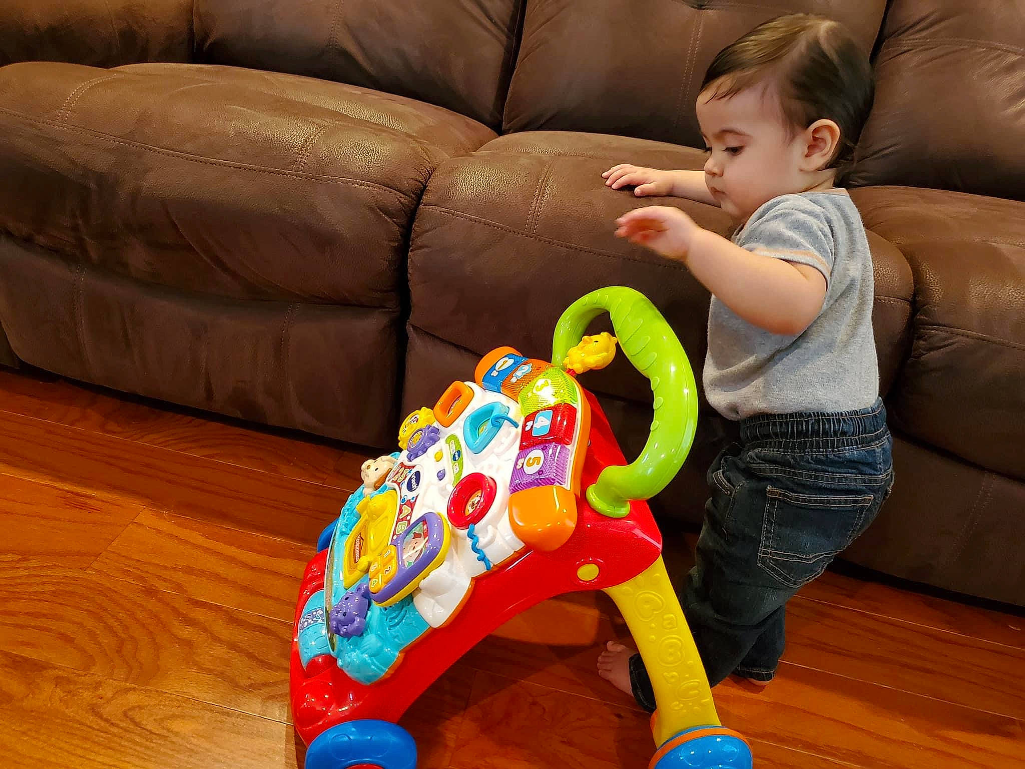 Nicholas Daniel Aguirre is registered to the contest to win money with this photo: comfort, couch, event, flooring, fun, furniture, hardwood, lap, leisure, person, play, room, sharing, sitting, sofa_bed, studio_couch, toddler, toy, varnish, wheel