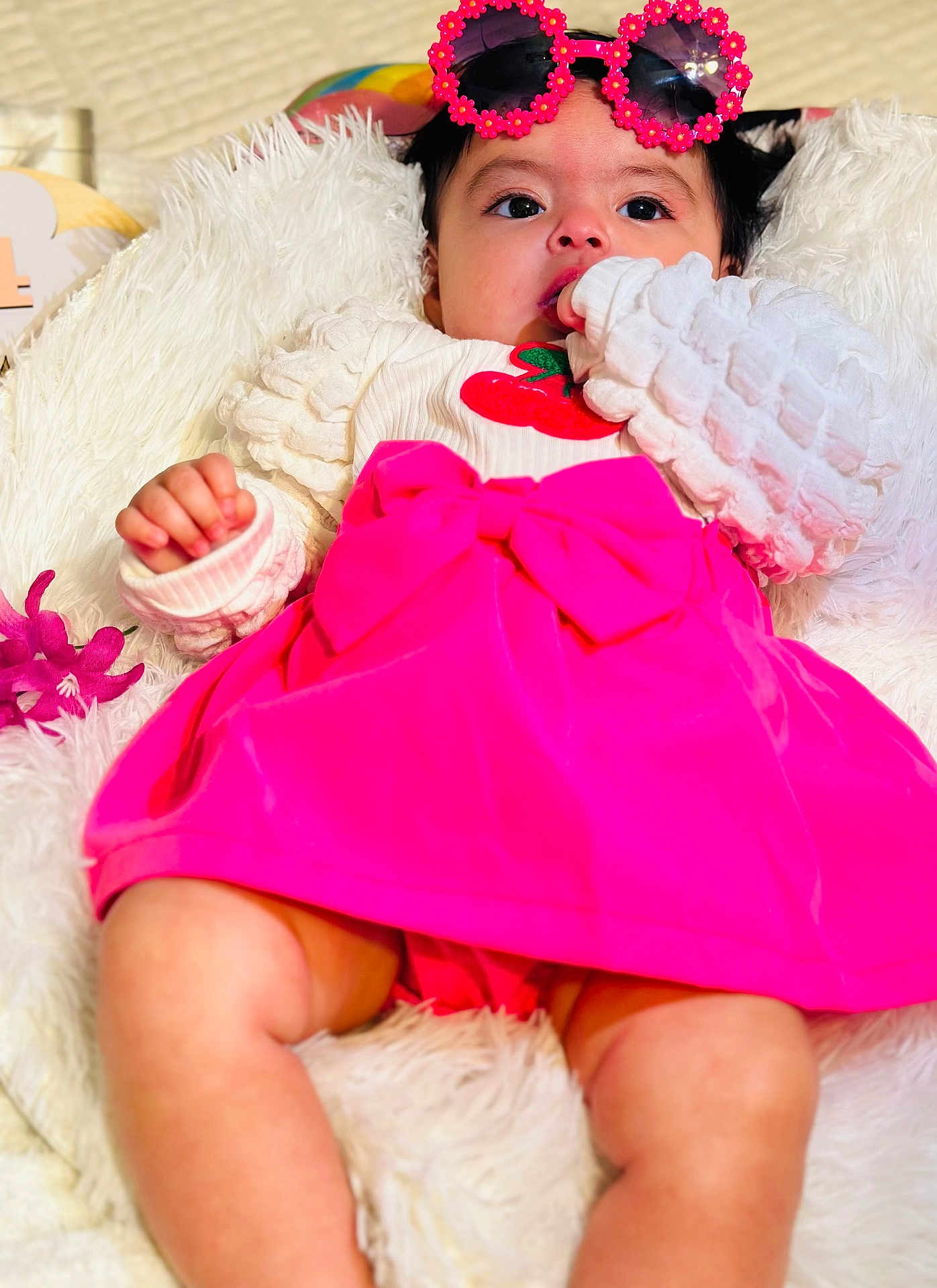 Loaiza joined the competition — help win amazing prizes! baby, child, pink_dress, bow, sunglasses, flower_glasses, blanket, white_blanket, hand, curious, lying_down, cute, infant, face, portrait, close_up, soft_texture, comfortable, indoors, colorful