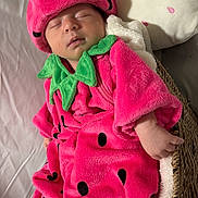 Hazel is registered to the contest to win money with this photo: baby, sleeping, strawberry_costume, pink, green, basket, blanket, pillow, soft, cute, infant, child, face, hand, cozy, resting, wearing, fabric, indoor, portrait