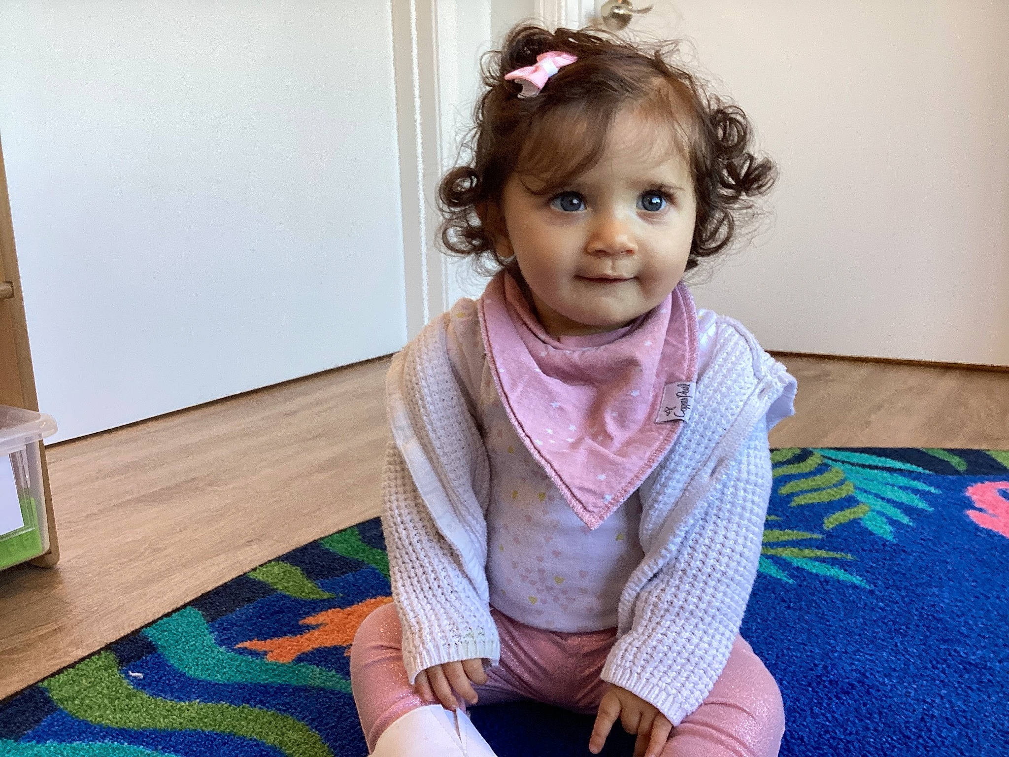 Elara joined the competition — help win amazing prizes! baby_toddler_clothing, cheek, child, chin, dress, face, fashion_accessory, flooring, happy, head, headgear, neck, pattern, person, scarf, sitting, skin, sleeve, stole, toddler