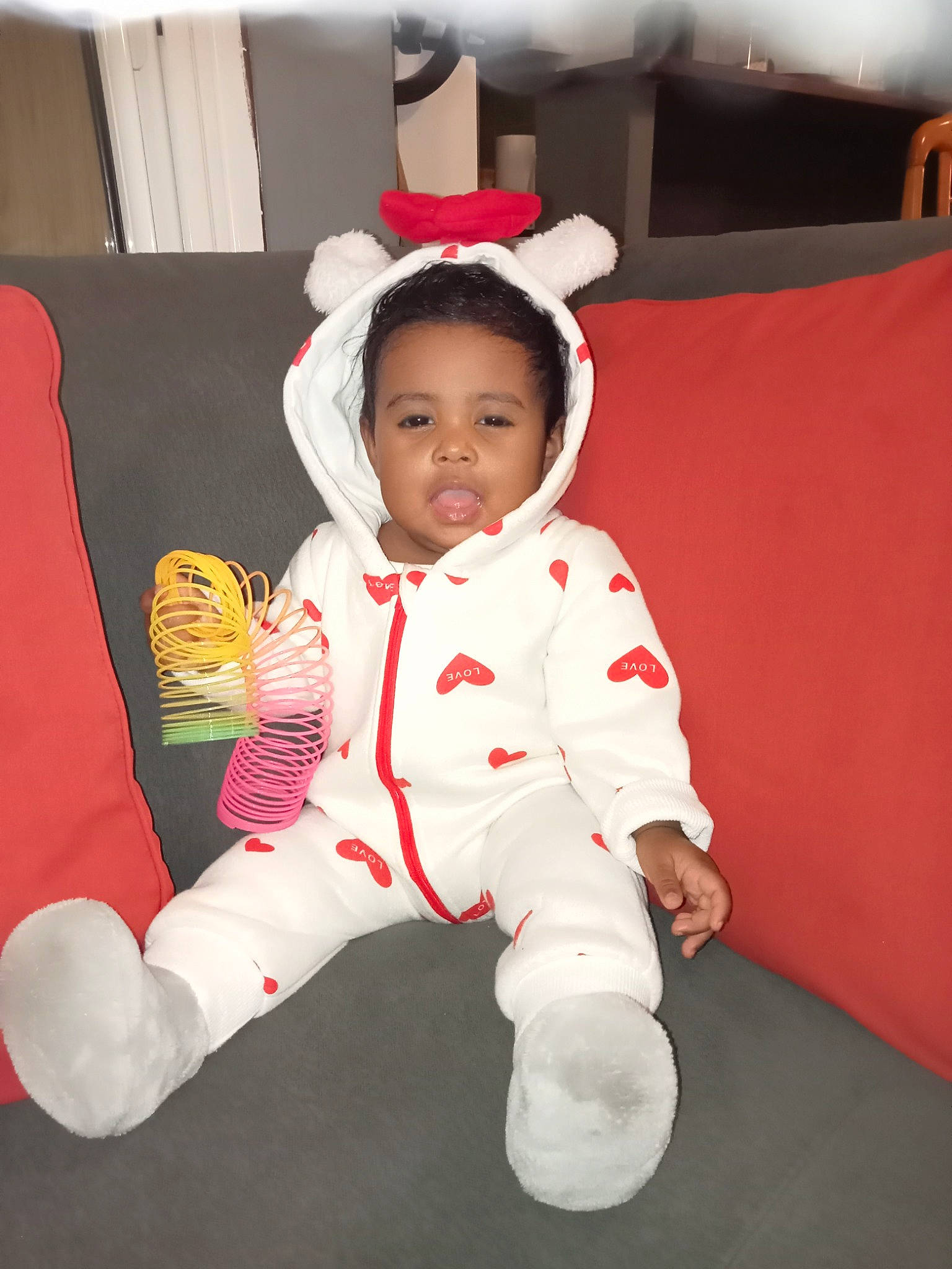 Bella participe au concours pour gagner de l'argent avec cette photo : baby, baby_toddler_clothing, carmine, child, comfort, costume, costume_hat, event, fictional_character, flooring, foot, fun, fur, happy, holiday, human_body, person, room, sitting, sleeve