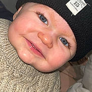 Liam participe au concours pour gagner de l'argent avec cette photo : baby, child, blue_eyes, smile, knitted_sweater, beanie, black_hat, close_up, face, cheeks, cute, portrait, indoor, warm_clothing, infant, happy, person, headwear, toddler, skin
