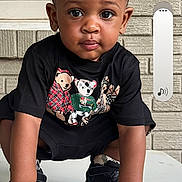Cartrail is registered to the contest to win money with this photo: toddler, child, portrait, crouching, sitting, looking_at_camera, serious, black_shirt, bear_graphic, shoes, table, outdoor, brick_wall, window, house_exterior, smartphone_screenshot, phone_icons, vertical_photo, daylight, face