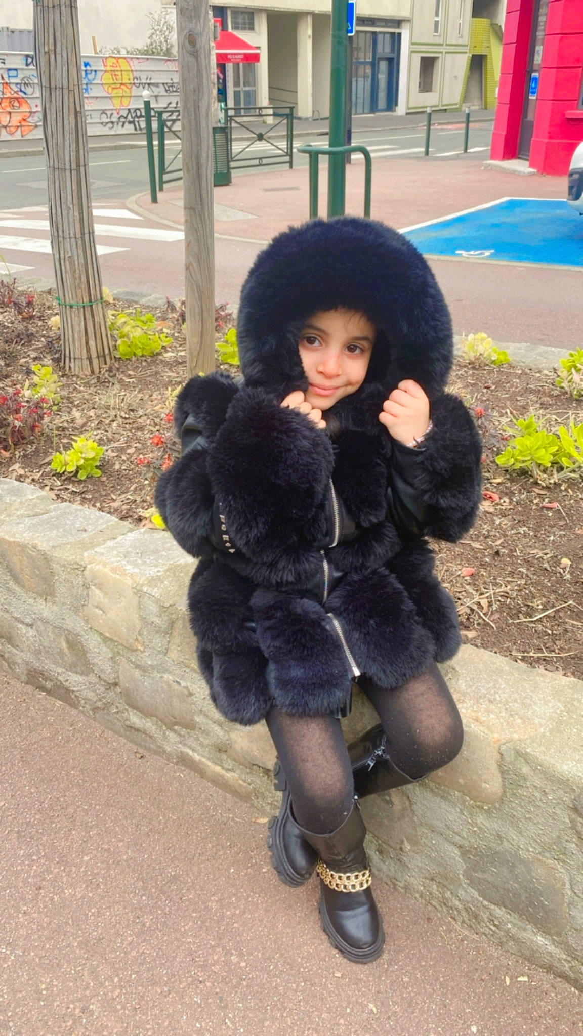 Aliya a rejoint le concours — aidez-le/la à gagner de superbes lots ! bangs, black_hair, brown_hair, costume, doll, fashion_accessory, fashion_design, fur, fur_clothing, hat, headwear, human_leg, joy, knee, long_hair, pedestrian, person, plant, sitting, thigh