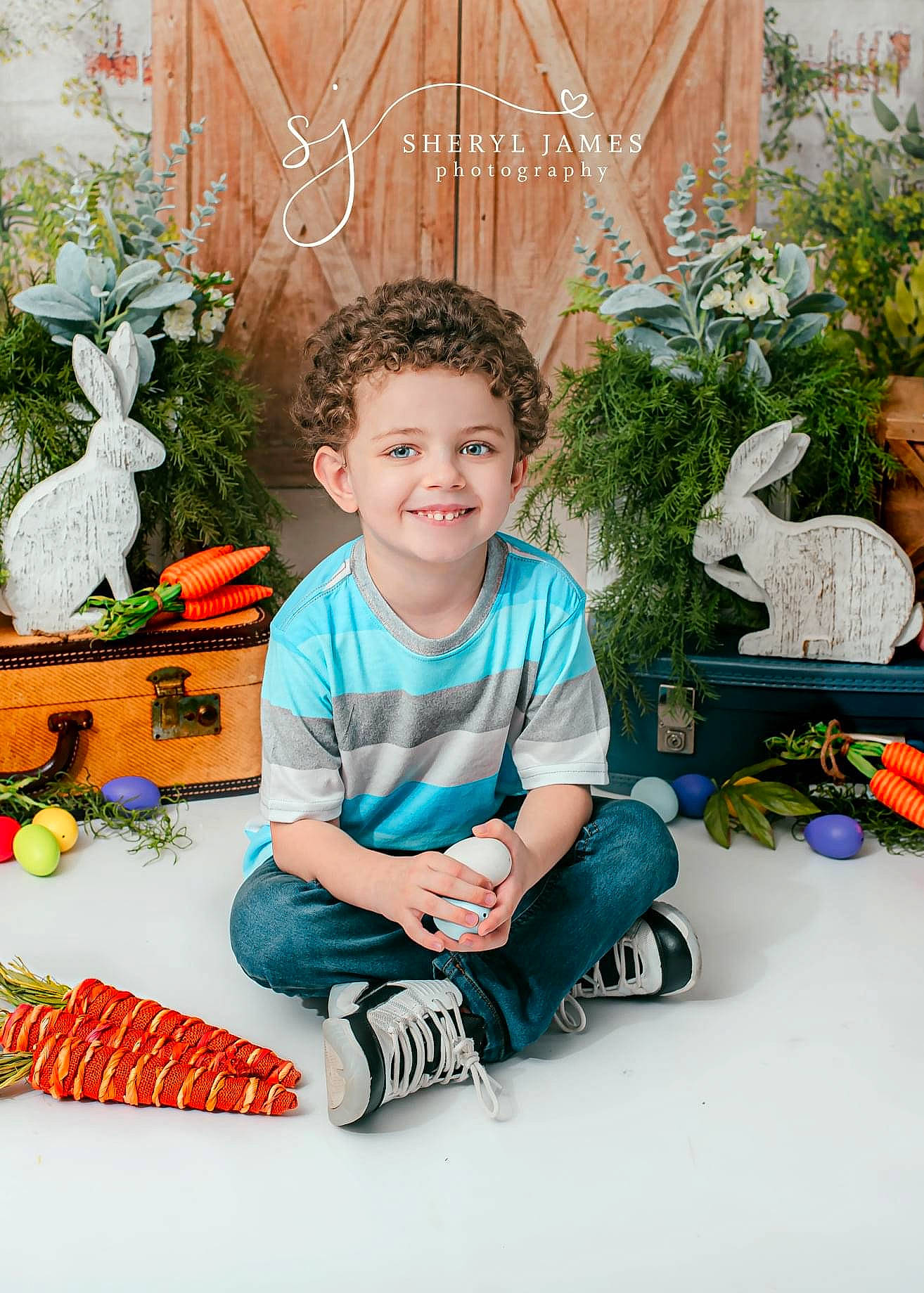 Douglas is registered to the contest to win money with this photo: baby_toddler_clothing, child, event, flowerpot, grass, happy, houseplant, joy, leisure, mammal, people, person, plant, sitting, sleeve, smile, snapshot, sneakers, t_shirt, toddler