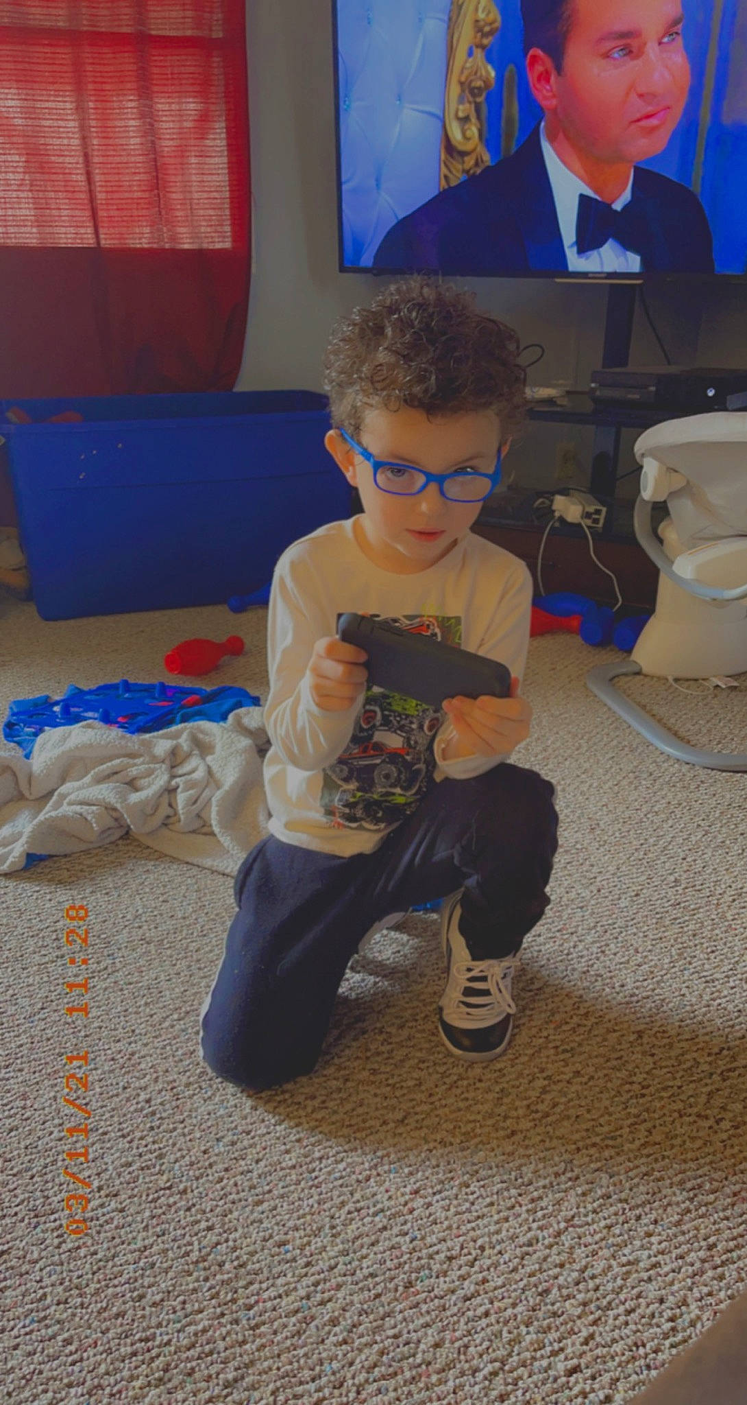 Douglas is registered to the contest to win money with this photo: animation, blue, chair, child, cup, event, eyewear, flooring, fun, leisure, mug, person, personal_protective_equipment, play, room, sitting, sneakers, t_shirt, toddler