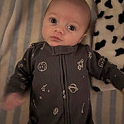 Hunter is registered to the contest to win money with this photo: baby, infant, onesie, space_theme, blanket, striped, plush, black_and_white, lying_down, indoor, cute, child, small, sleepwear, patterned_clothing, young, person, portrait, cozy, soft