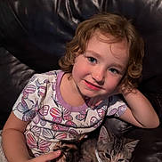 Haisley Mae joined the competition — help win amazing prizes! child, curly_hair, smile, couch, leather, cat, pets, collar, indoor, portrait, cozy, cute, person, relaxing, animal, feline, comfort, happy, casual_clothing, butterfly_pattern