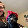 Reaper joined the competition — help win amazing prizes! puppy, dog, black_dog, pet, headband, red_cloth, person, indoor, portrait, smile, face, hand, cozy, wall_art, frame, home, cute, animal, holding, looking