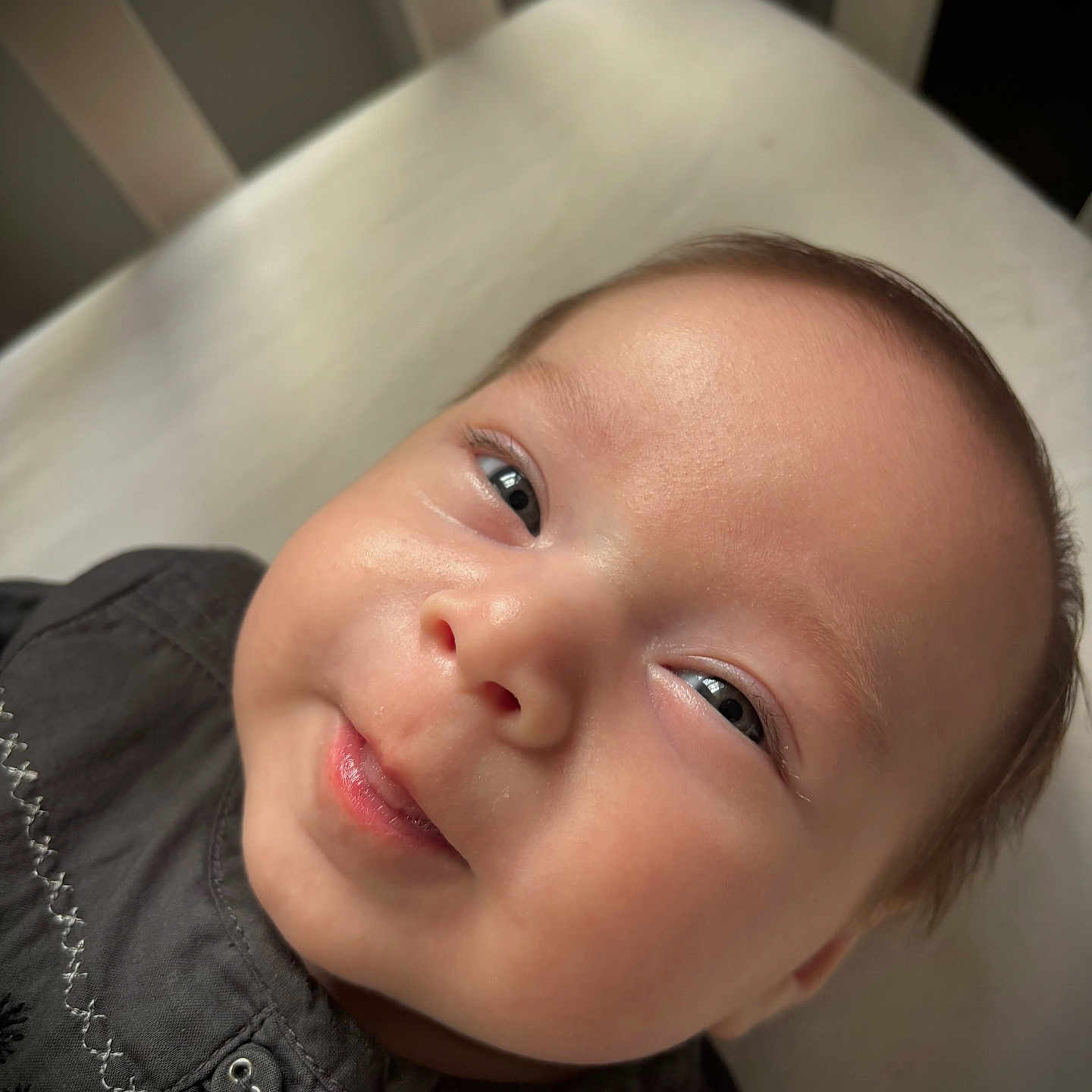 Mahé a rejoint le concours — aidez-le/la à gagner de superbes lots ! baby, button, child, close_up, clothing, cute, embroidery, expression, eyes, face, head, indoors, infant, lying_down, person, portrait, skin, smile, soft_light, young
