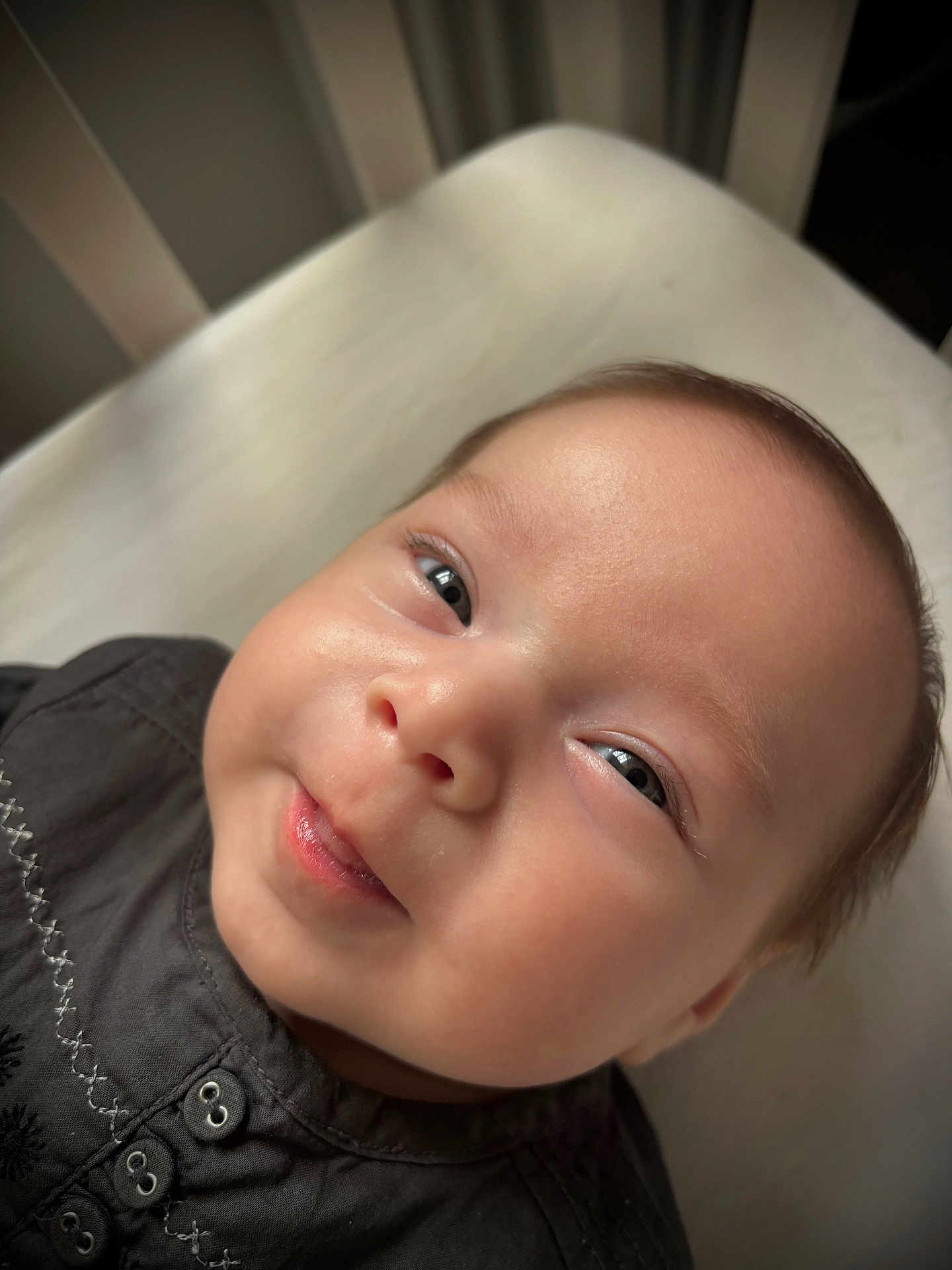 Mahé a rejoint le concours — aidez-le/la à gagner de superbes lots ! baby, infant, face, smile, close_up, eyes, skin, clothing, button, embroidery, lying_down, soft_light, portrait, cute, child, person, head, indoors, expression, young
