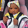baby, child, car_seat, blanket, headband, straps, indoor, portrait, infant, clothing, cute, face, hands, pink, yellow, colorful, person, sitting, closeup, expression