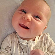 Natalee joined the competition — help win amazing prizes! baby, smile, face, onesie, elephant_pattern, child, infant, close_up, happy, cute, lying_down, soft_surface, skin, eyes, mouth, hand, clothing, portrait, newborn, expression