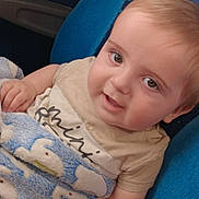 George joined the competition — help win amazing prizes! baby, child, blanket, blue, elephant_pattern, seat, cushion, smile, face, hand, clothing, cute, indoor, portrait, infant, young_child, happy, skin, head, eyes