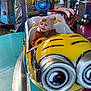 toddler, child, amusement_ride, minion, hat, jacket, smile, indoor, carnival, colorful, toy_car, face, people, ride, fun, winter_clothing, entertainment, happy, cute, playful