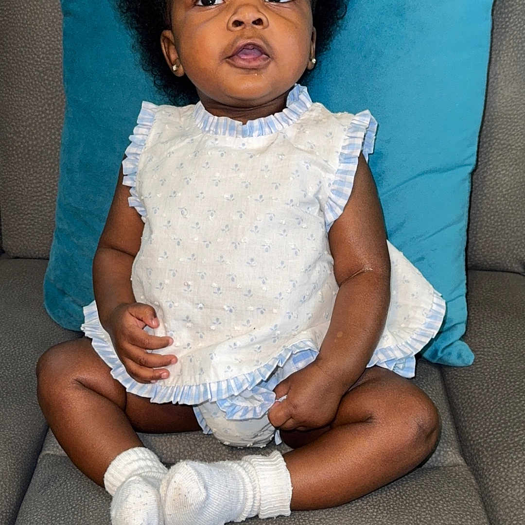 Skyler is registered to the contest to win money with this photo: child, clothing, couch, cushion, face, female, furniture, girl, happy, head, homedecor, hosiery, person, photography, pillow, portrait, shorts, sitting, smile, sock