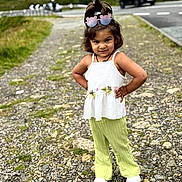 Devanshi Patel is registered to the contest to win money with this photo: child, girl, outdoor, path, rocks, greenery, road, car, sunglasses, white_top, green_pants, standing, posing, hair_tied, confident, footwear, nature, portrait, casual_clothing, daylight