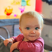 Lilija is registered to the contest to win money with this photo: baby, child, infant, playpen, curious, blue_eyes, smile, portrait, indoors, soft_light, blurry_background, maroon_shirt, cute, young_child, face, hands, looking, expression, closeup, person