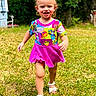 child, toddler, smiling, running, outdoor, grass, greenery, dress, colorful_clothing, hair_bows, sandals, happy, sunlight, portrait, young_child, playful, nature, daylight, cute, fun
