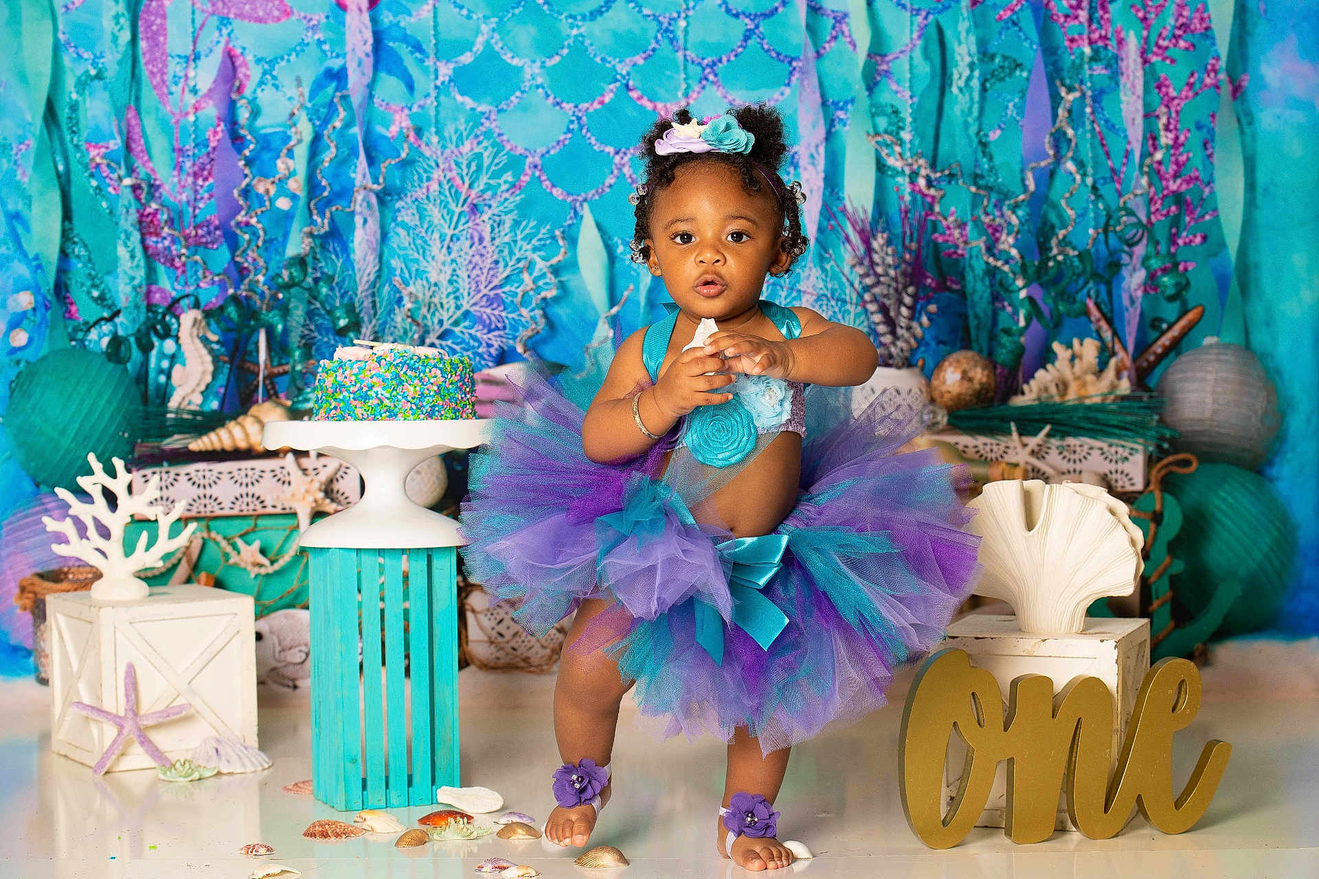 A'Myri joined the competition — help win amazing prizes! toddler, cake, birthday, tutu, seashells, decorations, purple, teal, barefoot, headband, smiling, party, celebration, ocean_theme, colorful, child, stand, photography, festive, one_year_old