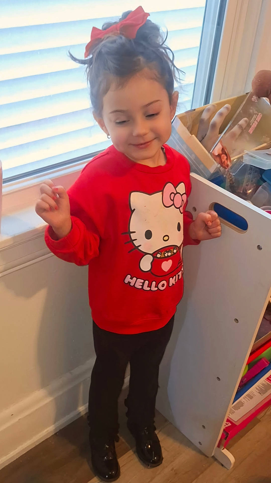 bodypart, child, clothing, face, female, finger, footwear, furniture, girl, hand, happy, head, person, photography, portrait, shoe, sleeve, smile, standing, wood