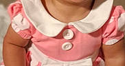 Malani is registered to the contest to win money with this photo: baby, child, smiling, pink_dress, polka_dot, headband, cute, happy, indoors, portrait, infant, dimple, sitting, white_collar, bow, button, face, skin, person, toddler