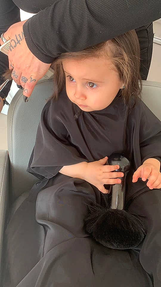 Mélina participe au concours pour gagner de l'argent avec cette photo : arm, baby, black_hair, cap, comfort, eye, face, finger, gesture, hairstyle, hat, human_body, joint, lap, lip, neck, person, shoulder, skin, thigh