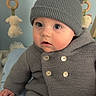 baby, child, knit_hat, pom_poms, grey_sweater, buttons, blue_blanket, plush_toys, indoor, cute, curious, infant, soft_toys, wooden_rings, face, portrait, warm_clothing, seated, baby_clothes, adorable