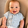 baby, smiling, high_chair, blue_eyes, striped_clothing, romper, infant, chubby_cheeks, sitting, child, cute, happy, indoor, seat_belt, baby_clothes, portrait, light_skin, short_hair, baby_boy, baby_girl
