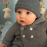 Raphaël participe au concours pour gagner de l'argent avec cette photo : baby, child, knit_hat, pom_poms, gray_sweater, blue_blanket, indoor, toy, curious, sitting, cute, infant, warm_clothing, face, eyes, buttoned_sweater, soft_toys, wooden_frame, cozy, portrait