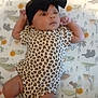 Amoura joined the competition — help win amazing prizes! adorable, animal_print, baby, bow, child, cozy, cute, headband, indoors, infant, lying_down, onesie, patterned_blanket, portrait, resting, sleepwear, small, socks, soft_toys, young