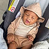 Zyair is registered to the contest to win money with this photo: baby, infant, child, sleeping, car_seat, hat, outfit, clothing, blanket, cozy, portrait, close_up, indoors, vehicle, seated, brown_clothing, peaceful, facial_expression, safe, photography