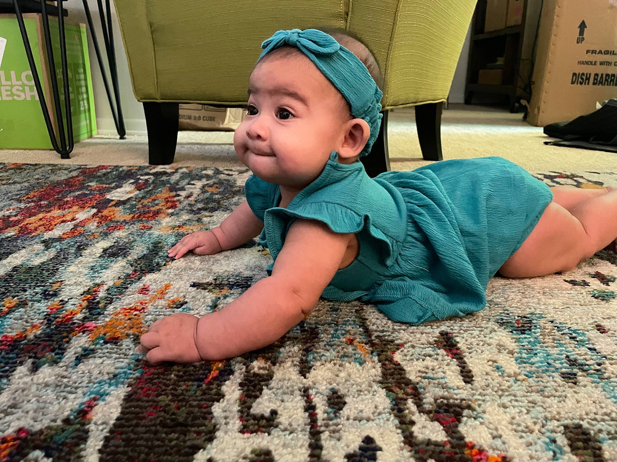 Delilah is registered to the contest to win money with this photo: baby, baby_toddler_clothing, cap, child, comfort, fashion_accessory, floor, flooring, fun, grass, happy, hat, leisure, pattern, person, play, room, sitting, smile, toddler