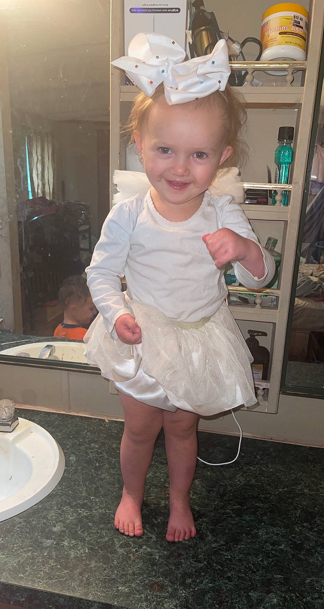 Chloe Ealy is registered to the contest to win money with this photo: baby_toddler_clothing, blond, child, dress, facial_expression, flooring, foot, fun, hairstyle, happy, headband, headpiece, human_leg, jewellery, joy, person, pink, serveware, skin, smile