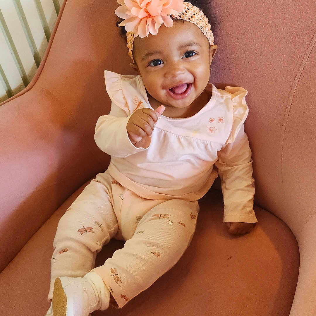Nova joined the competition — help win amazing prizes! armchair, baby, child, clothing, cozy, cute, cute_outfit, flower, footwear, furniture, happy, headband, indoor, infant, pattern, person, pink, portrait, sitting, smiling