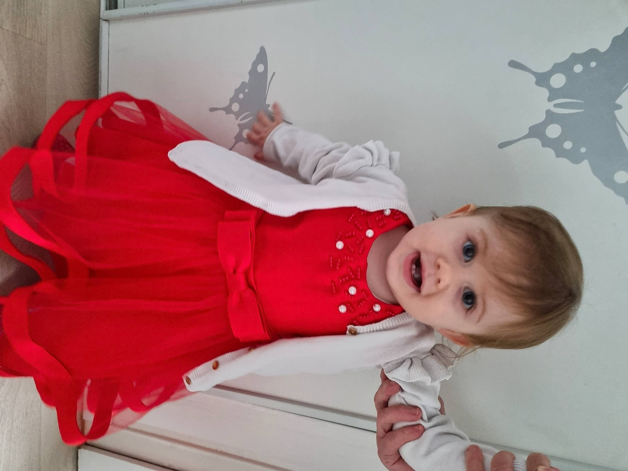 Yuna a rejoint le concours — aidez-le/la à gagner de superbes lots ! baby, baby_toddler_clothing, carmine, child, christmas, dress, event, happy, hat, human_leg, magenta, person, pink, red, sitting, sleeve, smile, sock, toddler, tree