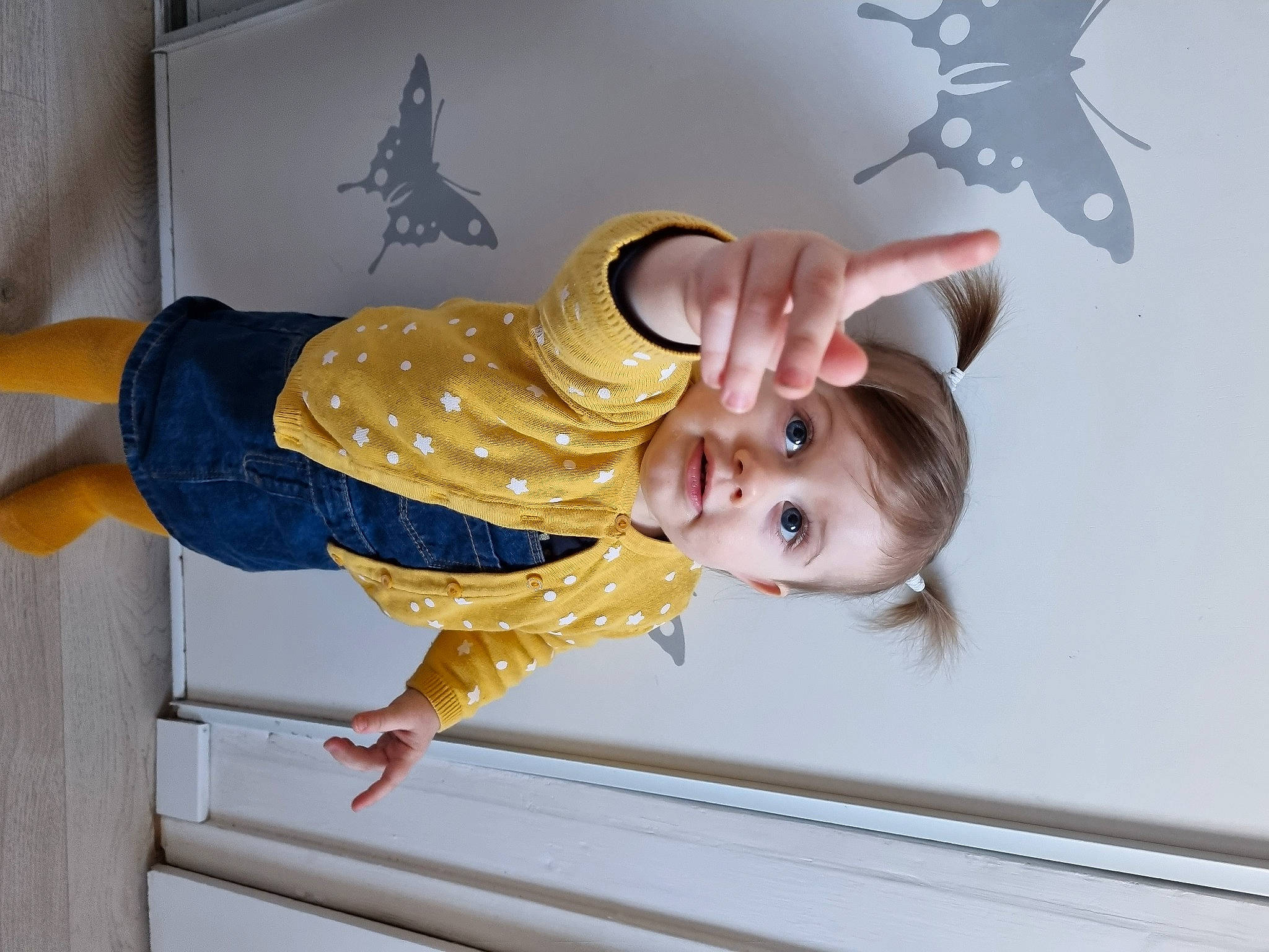 Yuna participe au concours pour gagner de l'argent avec cette photo : baby, baby_products, baby_safety, baby_toddler_clothing, child, fun, gesture, happy, logo, person, room, sleeve, smile, t_shirt, toddler, wood